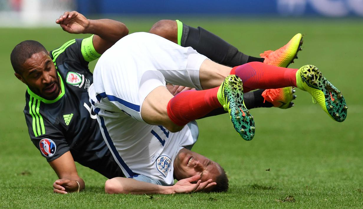 Jamie Vardy (kanan)  bertabrakan dengan pemain Wales, Ashley Williams pada laga Euro 2016 grup B di Stadion Bollaert-Delelis, Lens, Kamis (16/6/2016). (AFP/Paul Ellis)