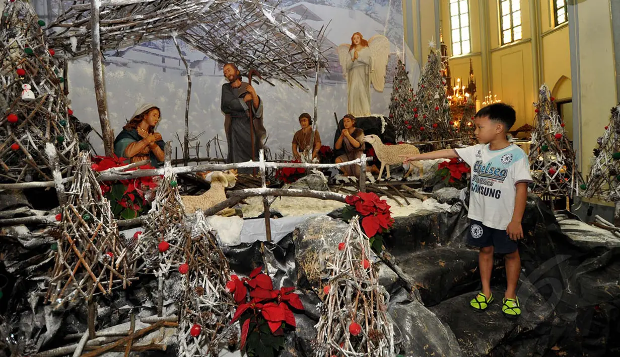 Di sekitar area Gereja Katedral, seorang anak melihat-lihat miniatur yang menggambarkan peristiwa kelahiran Yesus, Jakarta (24/12/2014). (Liputan6.com/Miftahul Hayat)
