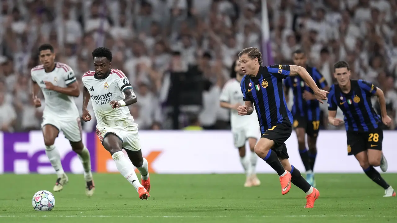 Pemain Real Madrid Vinicius Junior menggiring bola dikejar pemain Inter Milan Nicolo Barella