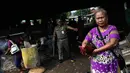 Seorang ibu menyelamatkan ayam peliharaannya saat proses penertiban bangunan liar dikolong tol Warakas, Jakarta, Kamis (11/8). Sebanyak 355 personil gabungan dikerahkan untuk menertibkan 80 bangunan liar di kawasan tersebut. (Liputan6.com/Faizal Fanani)