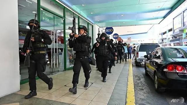 Anggota tim SWAT polisi mengambil posisi di luar salah satu pintu masuk ke mal setelah situasi penyanderaan dilaporkan terjadi di pinggiran kota Manila, 2 Maret 2020.