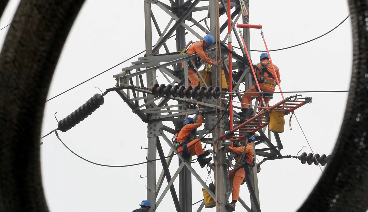 Petugas PLN memperbaiki Menara Sutet di Jalan Asia Afrika, Jakarta, Rabu (12/8/2015). Pekerjaan tersebut mengandung resiko besar karena jaringan listrik masih dipelihara tanpa dipadamkan. (Liputan6.com/Helmi Afandi)