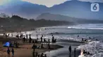 Wisatawan beraktifitas di pinggir pantai di kawasan Pantai Karang Naya, Pelabuhan Ratu, Sukabumi, Selasa (1/6/2021). Walaupun liburan lebaran telah usai sejumlah pantai di kawasan Pelabuhan Ratu masih dipadati pengunjung yang berasal dari Kota Jakarta dan Jawa Barat.(merdeka.com/Arie Basuki)