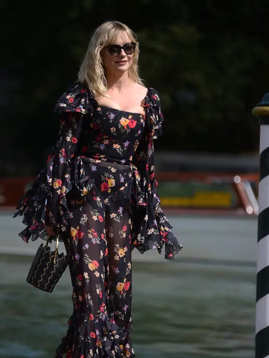 Aktris Kirsten Dunst berjalan saat tiba di Excelsior Hotel selama Festival Film Venice ke-74 di Venice Lido, Italia (4/9). Kirsten Dunst tampil cantik dengan Mengenakan gaun hitam bermotif bunga-bunga. (AFP Photo/Filippo Monteforte)