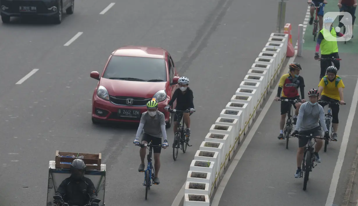 Warga bersepeda di jalan Sudirman, Jakarta, Selasa (1/6/2021). Direktorat Lalu Lintas Polda Metro Jaya tengah mengkaji sanksi sita sepeda apabila menemukan pesepeda yang gowes di luar jalur khusus yang telah disediakan. (merdeka.com/Imam Buhori)