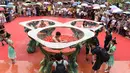 Penonton menyaksikan para peserta bersaing memakan cabai sambil berendam dalam gentong berisi cabai di Ningxiang, Provinsi Hunan, Tiongkok, 12 Agustus 2017. Kompetisi ini berhasil dimenangkan oleh seorang peserta yang mampu memakan 15 cabai. (STR / AFP)