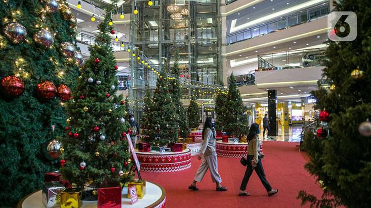 Pengunjung melintas di dekat Pohon Natal Raksasa di Mall Taman Anggrek, Jakarta, Senin (21/12/2020). Mal ini juga memasang pohon Natal megah dikelilingi beberapa pohon cemara asli dihiasi bola-bola kecil berwarna merah dan silver. (Liputan6.com/Faizal Fanani)