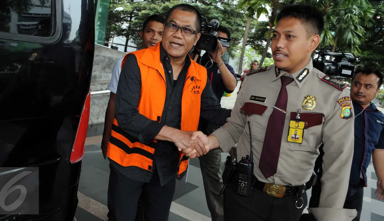 Tersangka suap pembahasan Perda pembentukan Bank Pembangunan Daerah Banten, Tri Satya Santoso berjabat tangan dengan petugas saat berjalan menuju mobil tahanan usai menjalani pemeriksaan di KPK, Jakarta, Senin (14/3). (Liputan6.com/Helmi Afandi)