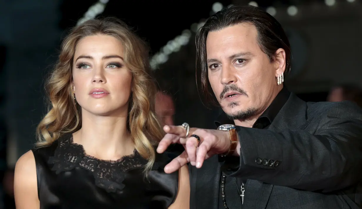 Johnny Depp saat menunjuk kearah media saat hadir dalam pemutaran perdana film "Black Mass " bersama sang istri di London, Inggris, Minggu (11/10/2015).Aktor 52 tahun ini terkenal setelah membintangi film Pirates of Caribbean. (REUTERS/Suzanne Plunkett)