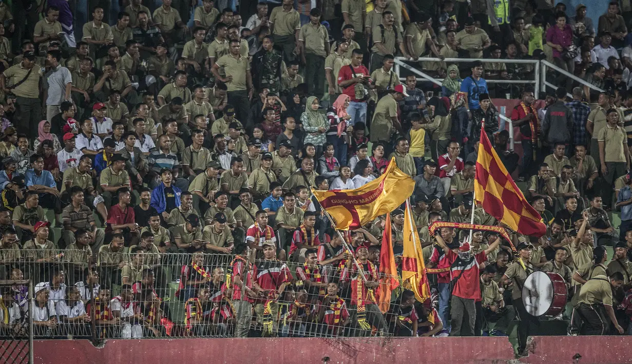Para anggota TNI mengibarkan bendera-bendera mendukung PS TNI bertanding melawan Pusamania Borneo FC di Stadion Gelora Delta Sidoarjo, Jawa Timur, Rabu (18/11/2015). (Bola.com/Vitalis Yogi Trisna)