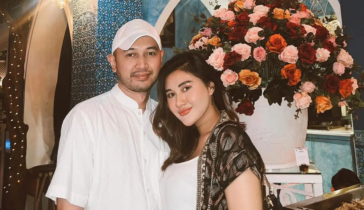 Saat buka puasa, Camelia tampil serasi dengan sang suami dengan dress putih dan outerwear bermotif. [Foto: @cameliaputricp]