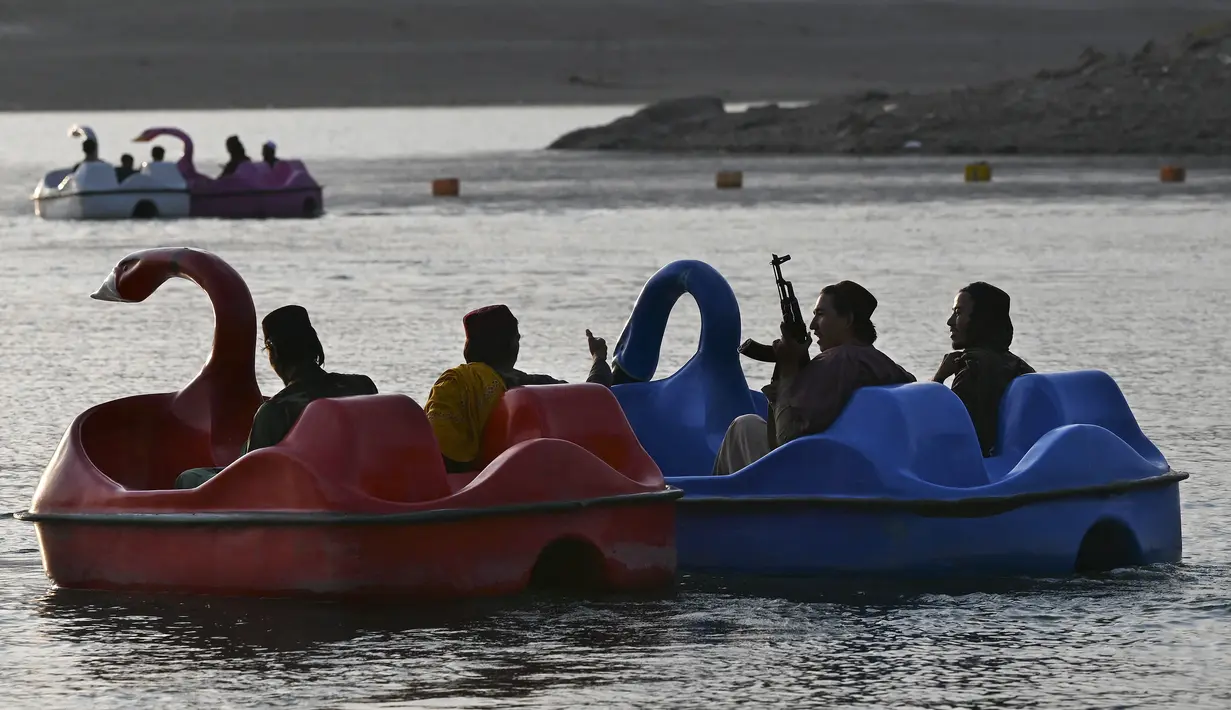 Sejumlah pasukan Taliban saat menaiki perahu kayuh di Danau Qargha di sebuah pekan raya di Kabul barat (28/9/2021). Mereka mengaku datang ke danau ini untuk bersenang-senang. (AFP/Wakil Kohsar)