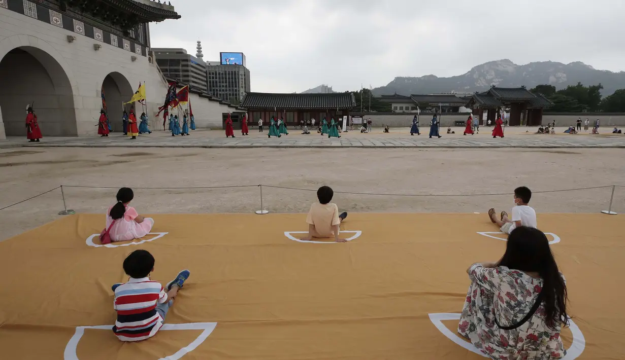 Pengunjung menonton sambil menjaga jarak sosial selama upacara berlakunya kembali pergantian Pengawal Kerajaan di Istana Gyeongbok, salah satu landmark terkenal Korea Selatan, di Seoul, Korea Selatan, Jumat (31/7/2020). (AP Photo/Lee Jin-man)