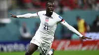 Penyerang Timnas Amerika Serikat Timothy Weah melakukan selebrasi setelah mencetak gol pertama timnya pada pertandingan sepak bola Grup B Piala Dunia Qatar 2022 antara Amerika Serikat dan Wales di Stadion Ahmad Bin Ali di Al-Rayyan, Doha, Qatar, Senin (21/11/2022). Pemilik nomor punggung 21 ini berhasil mencetak gol perdana bagi Amerika Serikat pada menit 36. (Jewel SAMAD/AFP)