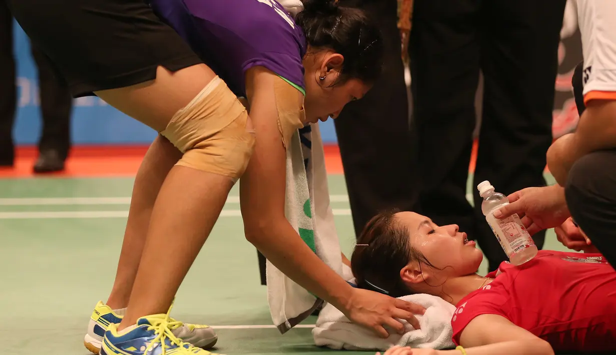 Linda Wenifanetri, membantu pebulutangkis Thailand, Ratchanok Intanon, yang mengalami cedera saat bertanding di babak 16 Besar Kejuaraan Dunia Bulutangkis 2015 di Istora Gelora Bung Karno, Jakarta. Kamis (13/8/2015). (Bola.com/Arief Bagus)