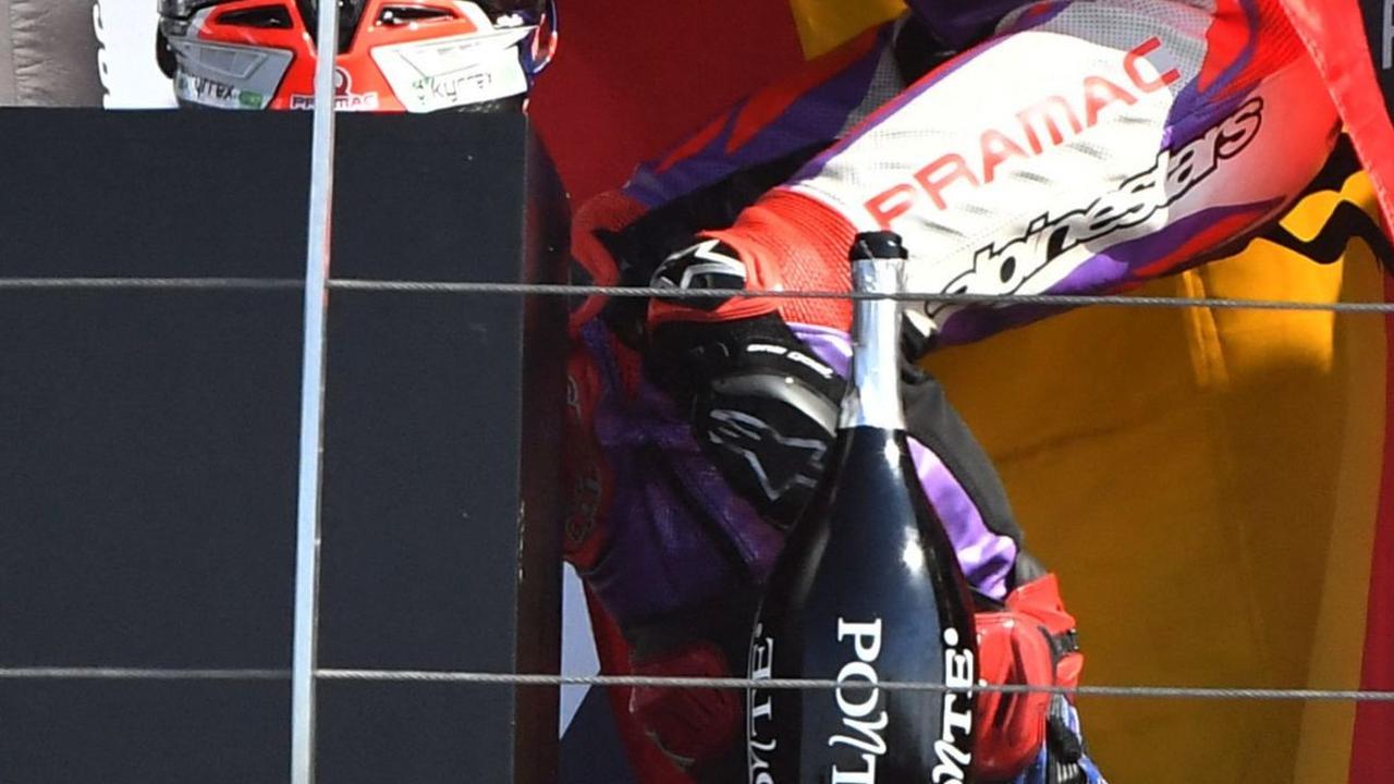 Gaya selebrasi Jorge Martin saat merayakan kemenangannya di atas podium.
