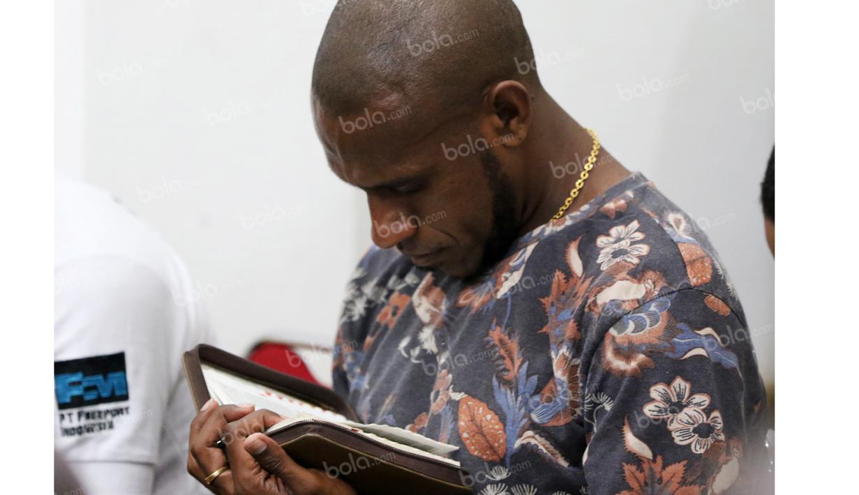 Boaz Solossa khusyuk membaca kitab suci dalam ibadah tim Persipura Jayapura di Hotel Yasmin, Jayapura, Kamis (28/4/2016). (Bola.com/Nicklas Hanoatubun)