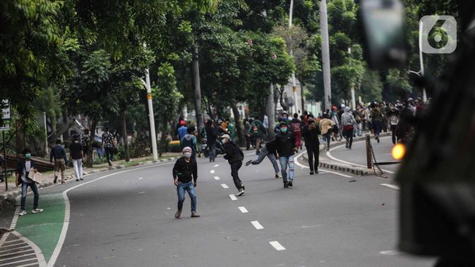 Pengunjuk rasa terlibat bentrok dengan aparat kepolisian di sekitar Patung Kuda, Jakarta Pusat, Selasa (13/10/2020). Unjuk rasa  menolak Omnibus Law Undang-Undang Cipta Kerja tersebut ricuh. (Liputan6.com/Faizal Fanani)