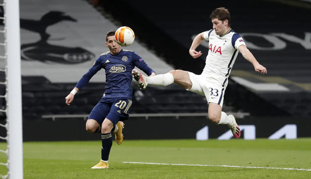 Bek Tottenham Hotspur, Ben Davies melakukan penyelamatan dari kejaran penyerang Dinamo Zagreb, Lirim Kastrati pada leg pertama babak 16 besar Liga Europa di ottenham Hotspur Stadium, Inggris, Jumat (12/3/2021). Hasil ini bagus bagi Spurs menyambut leg kedua. (AP Photo/Alastair Grant, Pool)