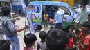 Sukarelawan memberikan makanan ringan kepada anak laki-laki setelah memberikan sampel swab untuk menguji virus corona Covid-19 di dalam sebuah van di New Delhi, India (1/7/2021).  Kegiatan ini diselenggarakan oleh Polisi Delhi bekerja sama dengan lab Star Imaging and Path. (AFP/Prakash Singh)