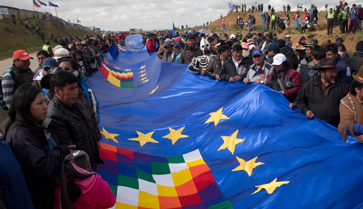 Sejumlah warga memegang bendera biru raksasa untuk dibentangkan di jalan raya antara Oruro dan La Paz Bolivia (10/3). Team hukum Bolivia berusaha mendapat akses berdaulat ke pantai Pasifik Chile. (AP Photo / Juan Karita)