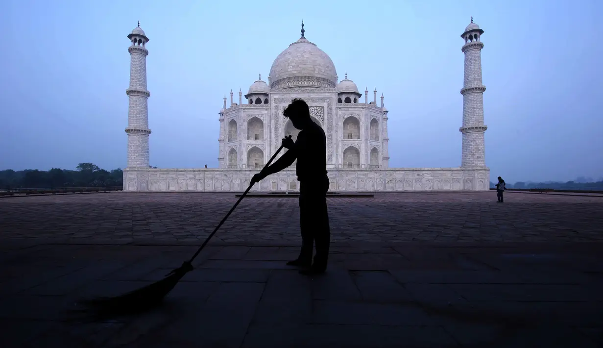 Seorang pria menyapu monumen Taj Mahal di Agra, India, Senin (21/9/2020). Taj Mahal dibuka kembali Senin setelah ditutup selama lebih dari enam bulan karena pandemi virus corona. (AP Photo/Pawan Sharma)