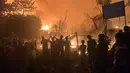 Orang-orang menyaksikan api muncul dari kebakaran di kamp pengungsi Rohingya di Kutupalong. (AP Photo/Shafiqur Rahman)
