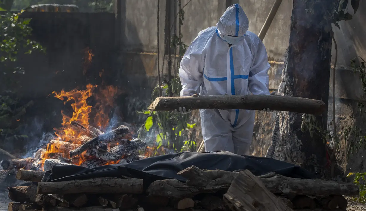 Kerabat seseorang yang meninggal karena COVID-19 melakukan ritual saat kremasi di Gauhati, India, pada Selasa (27/4/2021). Kasus virus corona COVID-19 di India melonjak lebih cepat dari tempat lain di dunia. (AP Photo/Anupam Nath)