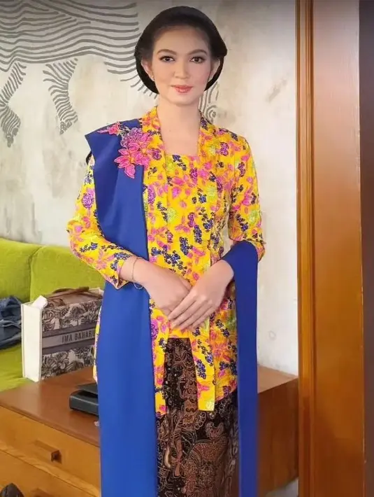 Anggunnya penampilan Selvi Ananda dibalut kebaya dan kain batik sebagai rok. Kebaya tradisional berwarna kuning dengan corak bunga yang semarak, dipadu dengan selendang biru tua dan kain batik cokelat gelap. [Foto: Instagram/selvi_gibran.id]