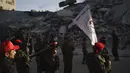 Militan Front Demokratik untuk Pembebasan Palestina (DFLP) berbaris melewati sebuah bangunan yang hancur oleh serangan udara selama parade di jalanan Kota Gaza, Selasa (8/6/2021). Gencatan senjata mengakhiri perang 11 hari antara Hamas sebagai penguasa Gaza dengan Israel. (AP Photo/Felipe Dana)