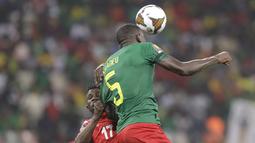 Penyerang Gambia Bubacarr Jobe melompat untuk merebut bola dari bek Kamerun Michael Ngadeu-Ngadjui pada pertandingan perempatfinal Piala Afrika 2021 di Japoma Stadium, Minggu (30/1/2022) dini hari WIB. Kamerun melangkah ke semifinal usai menang atas Gambia, 2-0. (AP Photo/Sunday Alamba)
