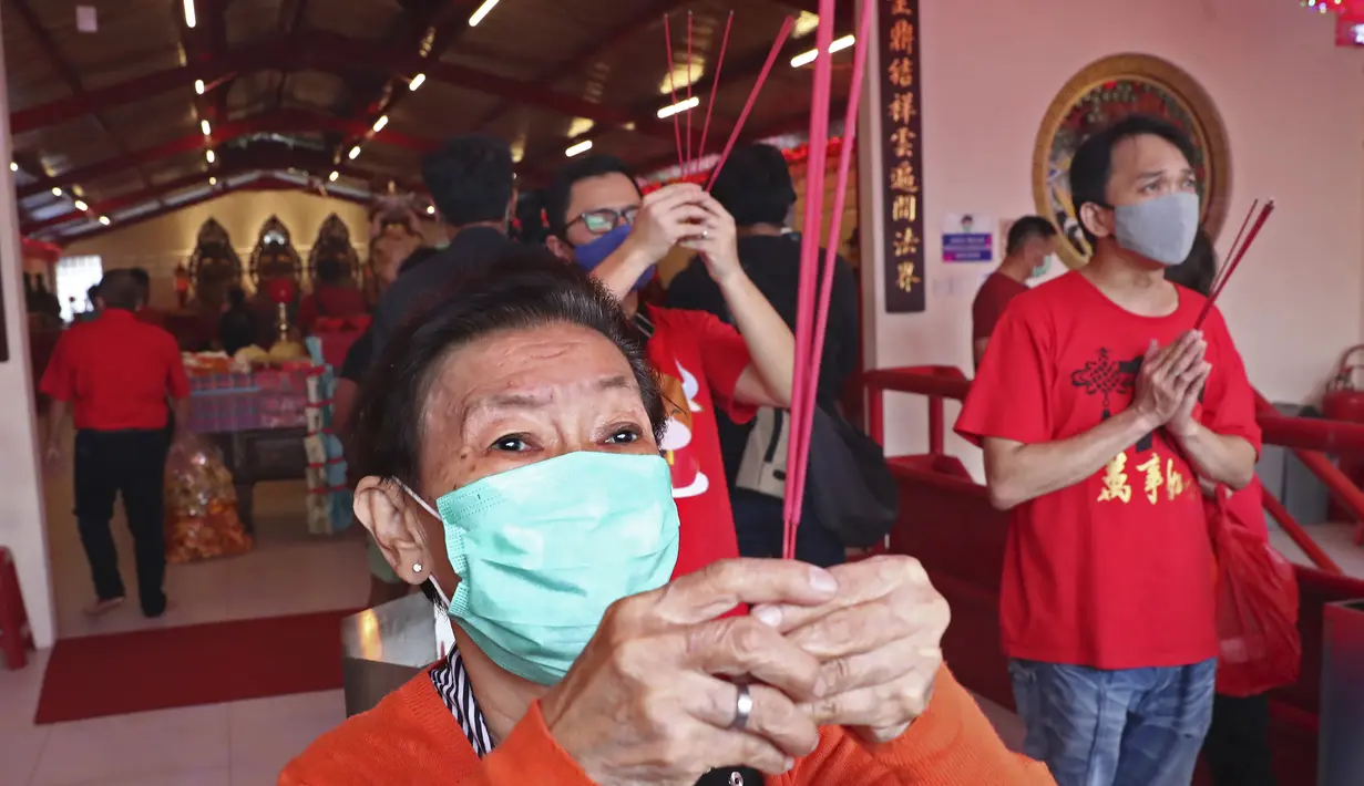 Warga keturunan Tionghoa yang mengenakan masker bersembahyang saat Tahun Baru Imlek di sebuah kuil di kawasan China Town, Jakarta, Jumat (12/2/2021). Tradisi sembahyang yang dilakukan pada perayaan tahun baru Imlek kali ini dibatasi untuk mencegah penyebaran covid-19.  (AP Photo/Tatan Syuflana)
