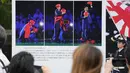 Orang-orang menonton gambar mantan Perdana Menteri Jepang Shinzo Abe sebelum berdoa di kuil Zojoji di Tokyo, Sabtu, 8 Juli 2023. (AP Photo/Shuji Kajiyama)