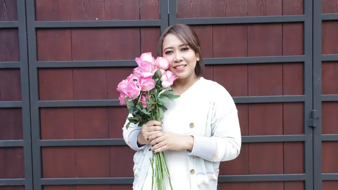 wanita januari tampak bahagia dengan bunga