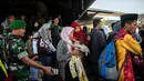 Seorang pria membawa anaknya ketika mereka tiba dalam penerbangan evakuasi oleh TNI dari Palu di Surabaya, Kamis (4/10). Sebanyak 1.411 orang telah dikonfirmasi tewas akibat bencana tersebut. (AFP Photo/Juni Kriswanto)