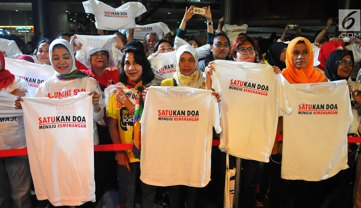 Pendukung Jokowi-Ma'ruf Amin mengangkat kaus pada acara Doa Bersama Lintas Agama dan Festival Seni Budaya di Jakarta, Jumat (12/4). Acara yang digelar Gerakan Alumni UI dan IKJ mengusung tema "SATUkan Doa menuju Kemenangan". (Liputan6.com/Angga Yuniar)