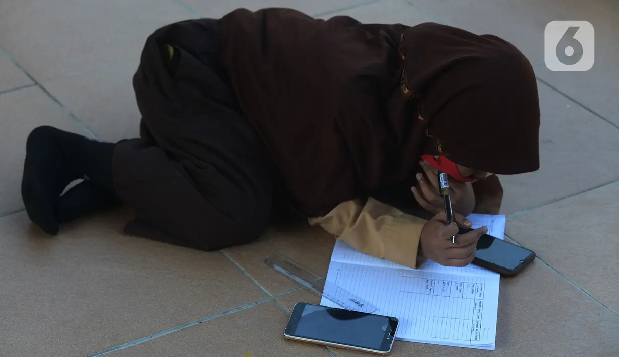 Siswa belajar di kolong rel kereta api Mangga Besar, Jakarta,Rabu (19/8/2020). Proses belajar siswa tersebut menggunakan modem paket internet wifi gratis yang disediakan untuk mengikuti pembelajaran jarak jauh. (merdeka.com/Imam Buhori)