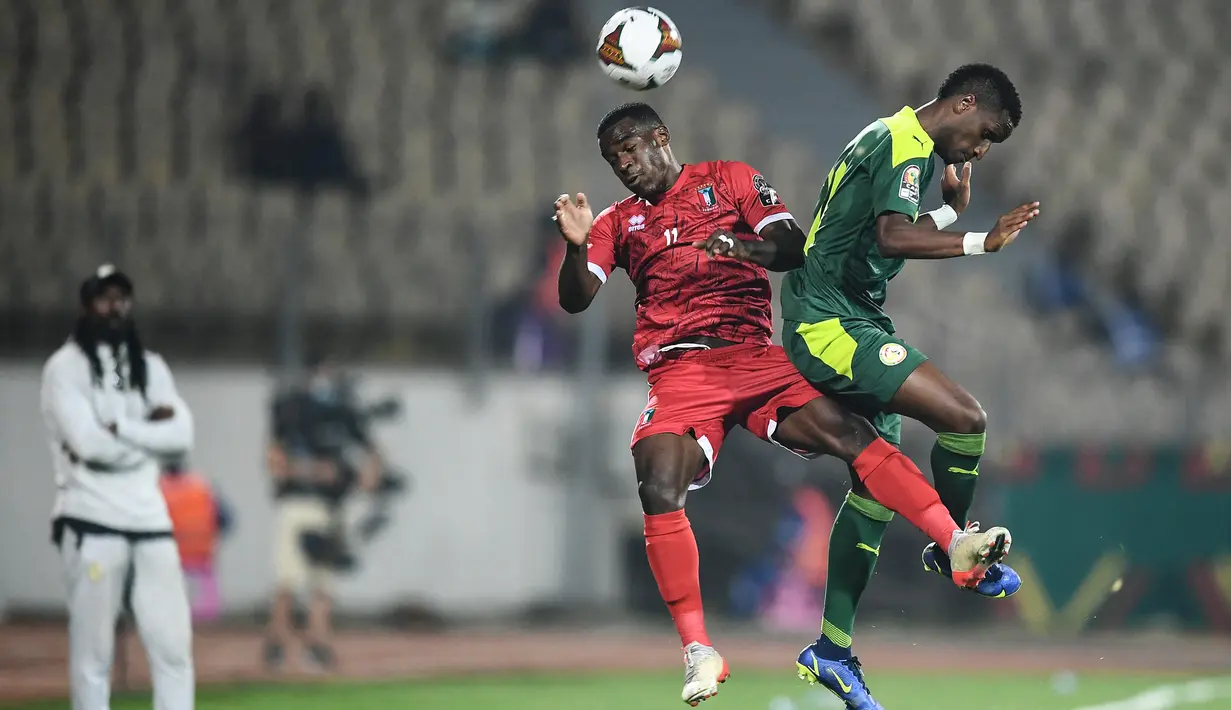 Bek Guinea Ekuatorial Basilio Ndong (tengah) dan bek Senegal Bouna Sarr (kanan) melompat untuk memperebutkan bola selama pertandingan perempat final Piala Afrika (CAN) 2021 di Stade Ahmadou Ahidjo di Yaounde (31/1/2022). Senegal menang atas Guinea Ekuatorial 3-1. (AFP/Charly Triballeau)