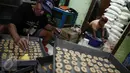 Pekerja menyelesaikan produksi kue kering di Industri kue rumahan Kwitang Pusaka, Jakarta,  (21/6). Produksi kue kering industri rumahan mencapai 30 kaleng besar per hari yang dijual ke agen dengan harga Rp500 ribu per kaleng. (Liputan6.com/Faizal Fanani)