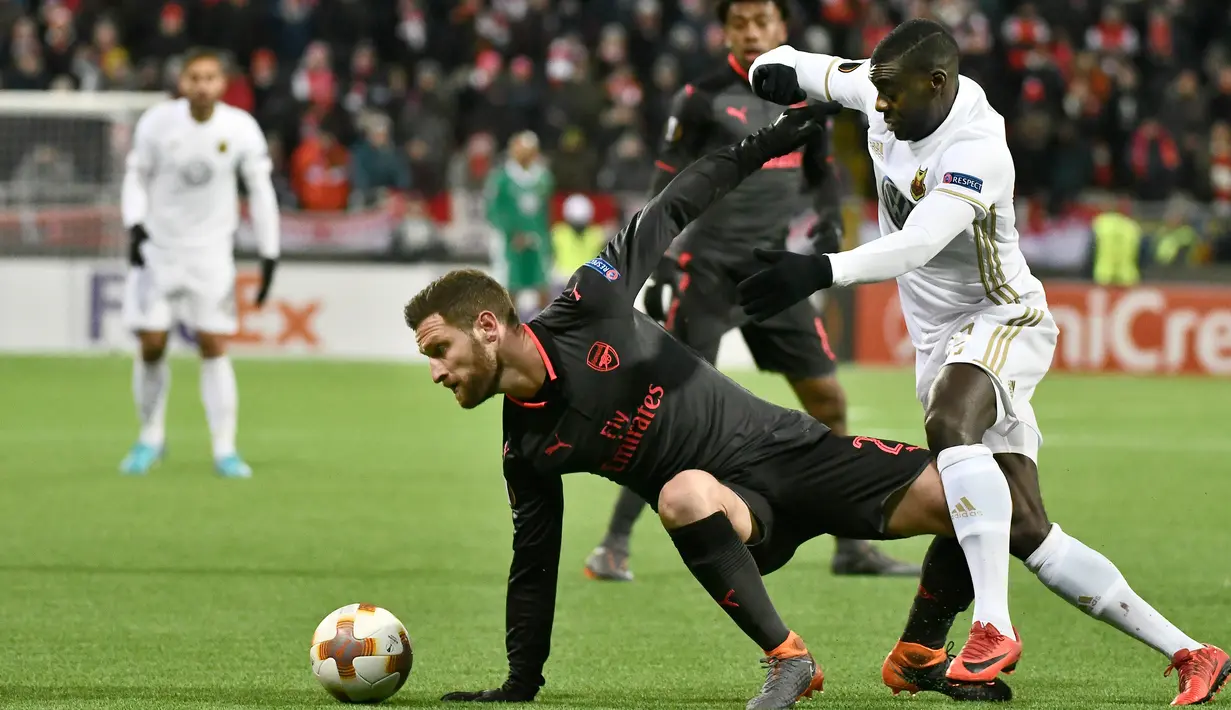 Pemain Arsenal, Shkodran Mustafi berebut bola dengan pemain Ostersunds, Ken Sema pada laga leg pertama babak 32 besar Liga Europa di Jamtkraft Arena, Jumat (16/2). Arsenal meraih kemenangan mudah 3-0. (Robert HENRIKSSON/TT NEWS AGENCY/AFP)