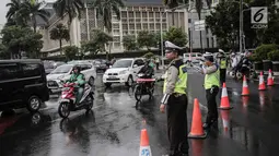 Polisi melakukan pengalihan arus lalu lintas terkait Malam Munajat 212 di Medan Merdeka Barat dan Utara, Jakarta, Kamis (21/2). Polisi menurunkan 12 ribu personel untuk mengamankan Malam Munajat 212 di Monas. (Liputan6.com/Faizal Fanani)