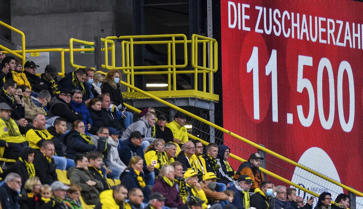 Suporter saat menyaksikan pertandingan antara SC Freiburg melawan Borussia Dortmund pada laga Bundesliga, Sabtu (3/10/2020). Sejumlah liga di Eropa telah mengijinkan fans menonton langsung pertandingan di stadion. (AP Photo/Martin Meissner)