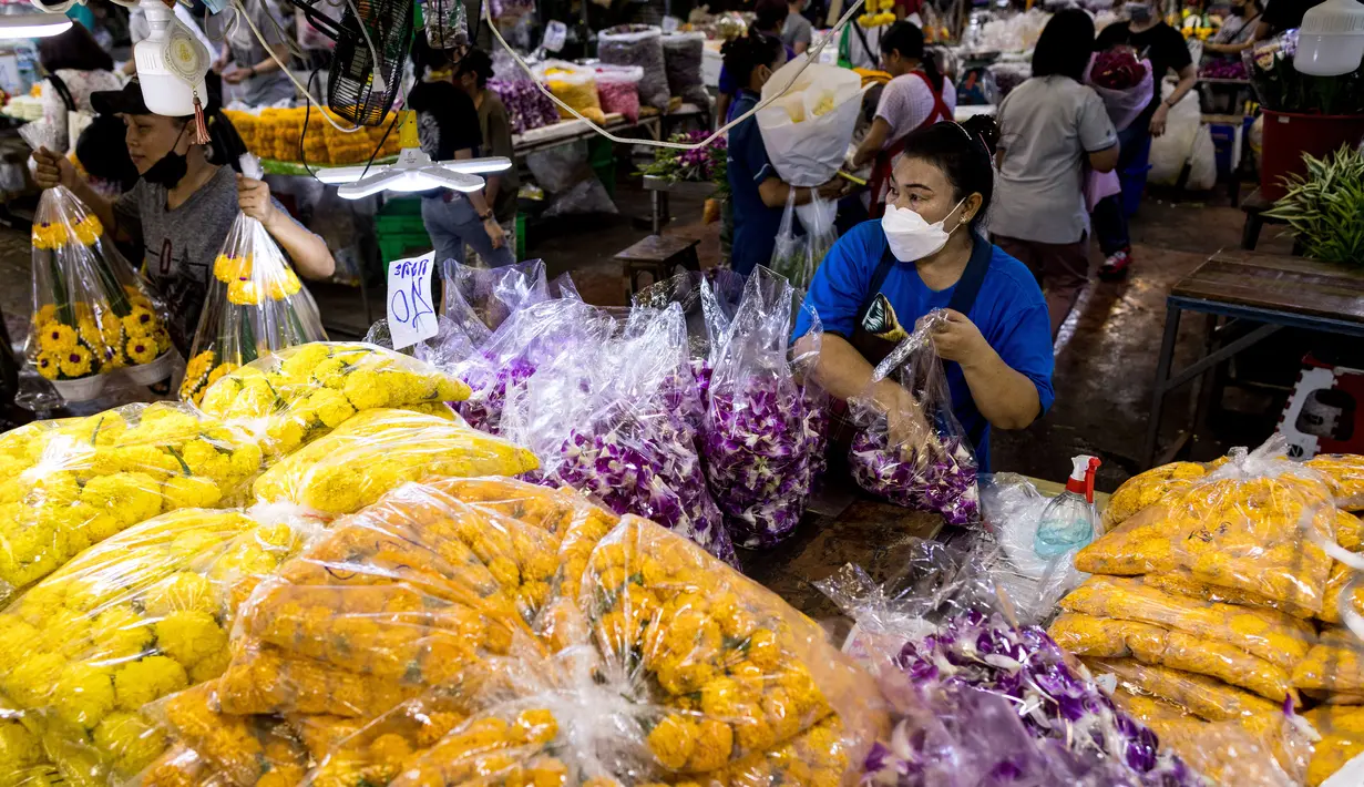 Seorang wanita mengemas anggrek menjelang Loy Krathong di pasar bunga Pak Khlong Talat, Bangkok, Kamis (18/11/2021). Bulan November ini Thailand akan mengadakan festival Loy Krathong di mana warga akan menghanyutkan keranjang berisi bunga dan lilin di sungai, kolam atau danau. (Jack TAYLOR/AFP)