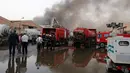 Pasukan keamanan dan pemadam berkumpul di lokasi kebakaran gudang surat suara terbesar Irak di Baghdad, Minggu (10/6). Gudang itu dilalap api sebelum dilakukan penghitungan kembali surat suara sebagaimana yang diperintahkan Parlemen. (AP/Karim Kadim)