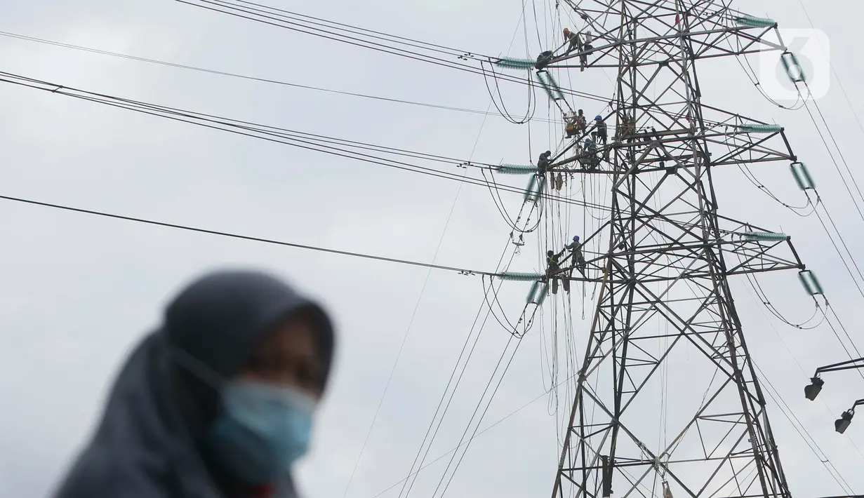 Pekerja menyelesaikan pekerjaan jaringan SUTET di Tangerang, Banten, Senin (2/1/2021). PT PLN (Persero) memiliki pasukan khusus yang terlatih melakukan pemeliharaan, perbaikan, dan penggantian perangkat isolator, konduktor maupun komponen lainnya pada jaringan listrik. (Liputan6.com/Angga Yuniar)