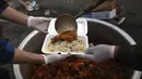 Sukarelawan menyiapkan makanan berbuka puasa gratis untuk orang-orang yang membutuhkan selama bulan puasa suci Ramadan di Kabul, Afghanistan, Kamis (7/5/2020). Muslim di seluruh dunia melewati Ramadan tahun ini di tengah pandemi virus corona COVID-19 dan PHK. (AP Photo/Rahmat Gul)