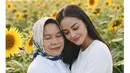 Ririn Ekawati andalkan AI untuk obati rasa rindunya pada sang ibu. Berlatar taman bunga matahari, Ririn Ekawati nampak memeluk sang ibu dalam balutan atasan putih yang serasi [@ririnekawati]