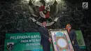 Gubernur DKI Jakarta Anies Baswedan memegang kaligrafi Alquran saat melapas Kafilah Provinsi DKI Jakarta untuk mengikuti MTQ Tingkat Nasional XXVII, Jakarta, Kamis (4/10). Anies berharap Kafilah DKI dapat meraih juara umum. (Liputan6.com/Faizal Fanani)