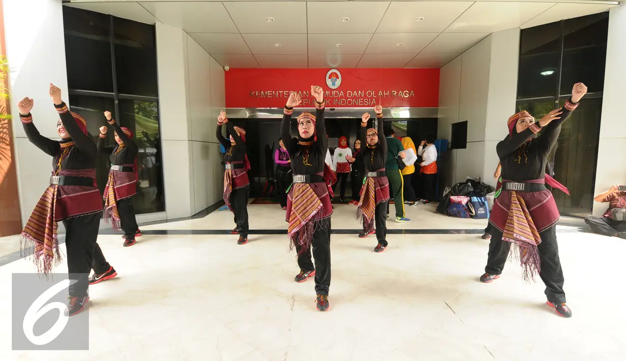 Salah satu peserta Lomba Senam Poco-Poco Nusantara berlatih keserasian jelang berlomba di halaman Kemenpora, Jakarta, Jumat (12/2/2016). Lomba ini memperebutkan piala Ibu Negara RI dan piala Menpora. (Liputan6.com/Helmi Fithriansyah)