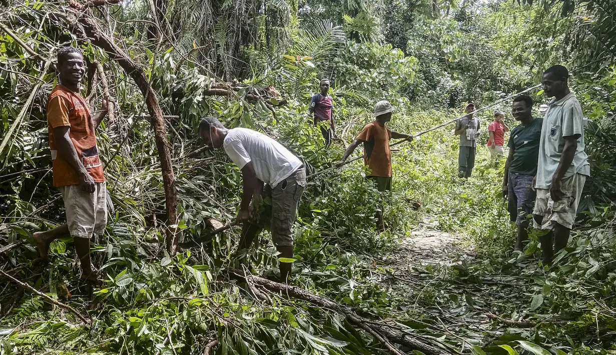 Warga Mahanoro terlihat membersihkan kerusakan yang disebabkan oleh berlalunya topan Batsirai pada 6 Februari 2022. Topan Batsirai melemah tetapi banjir masih diperkirakan terjadi karena hujan lebat setelah melanda Madagaskar timur dengan angin kencang. (Laure Verneau / AFP)